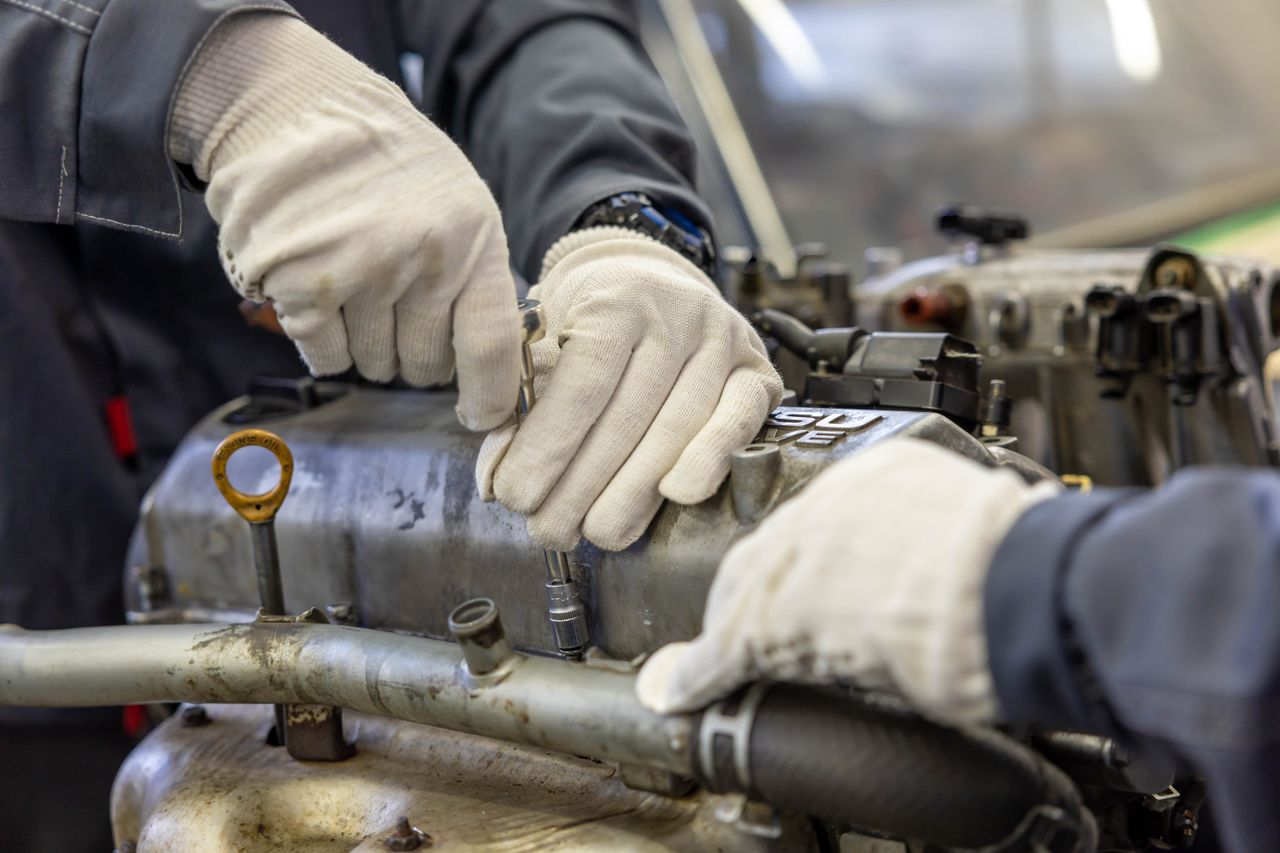 Crafting Captivating Headlines: Your awesome post title goes here Close-up of mechanics hands repairing engine, showcasing teamwork and skill.