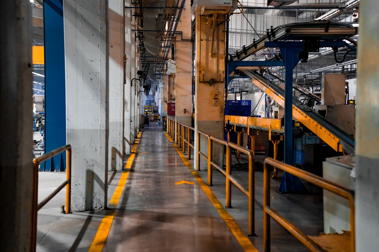 Mastering the First Impression: Your intriguing post title goes here Wide view of a modern factory interior showcasing industrial machinery and conveyor systems.